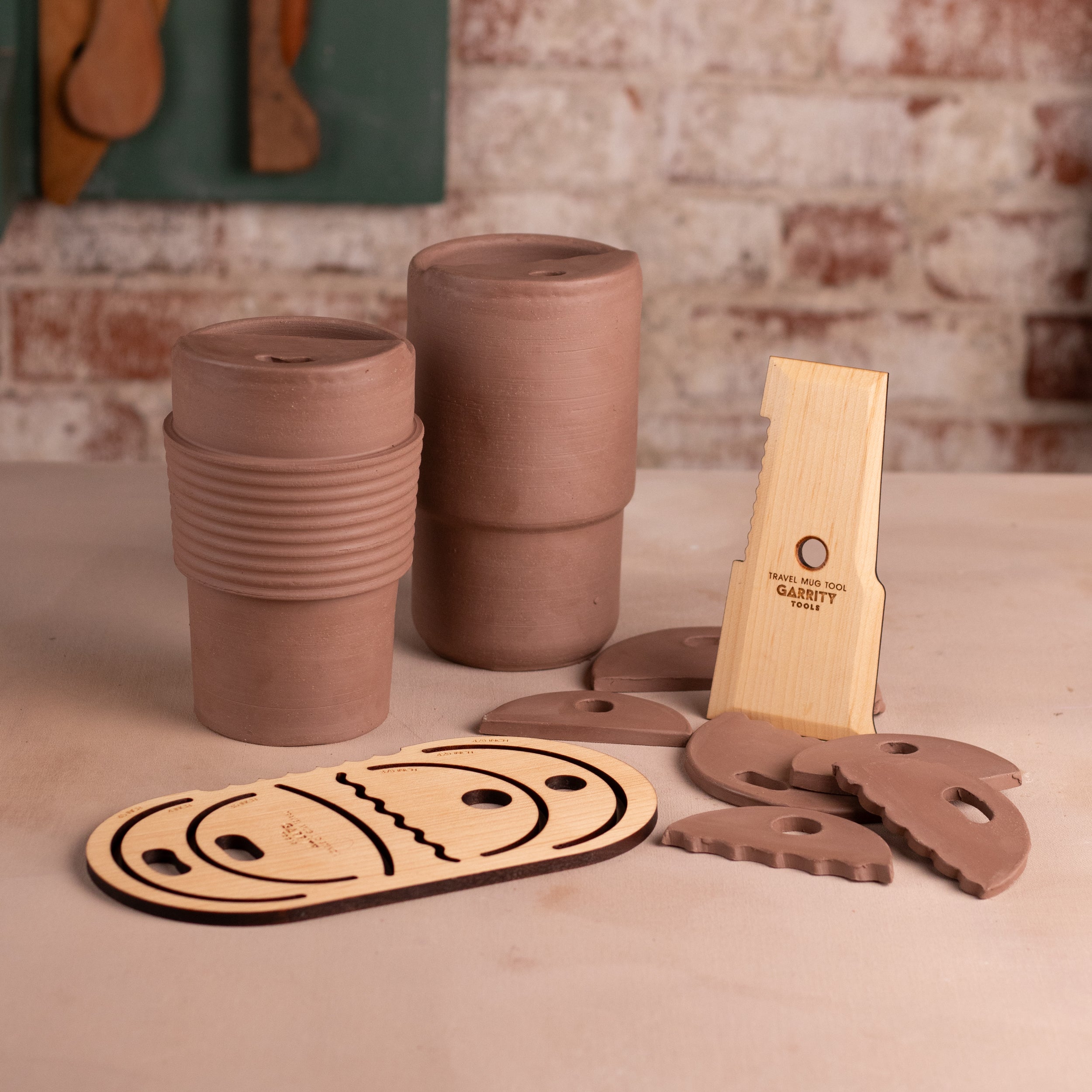 Terracotta cups and wooden tools on a stone surface with a rustic background