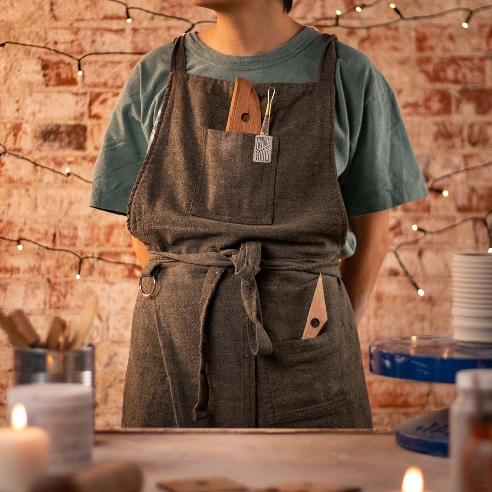 person standing wearing a potter's apron with Garrity Tools in the pockets