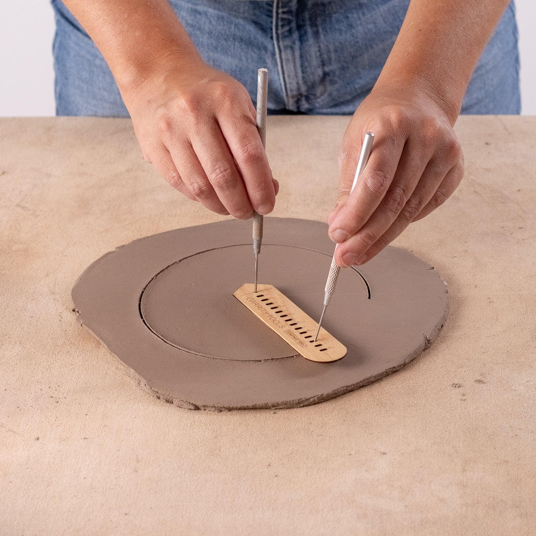 ceramicist uses Garrity Tools Compass wooden pottery tool on clay slab