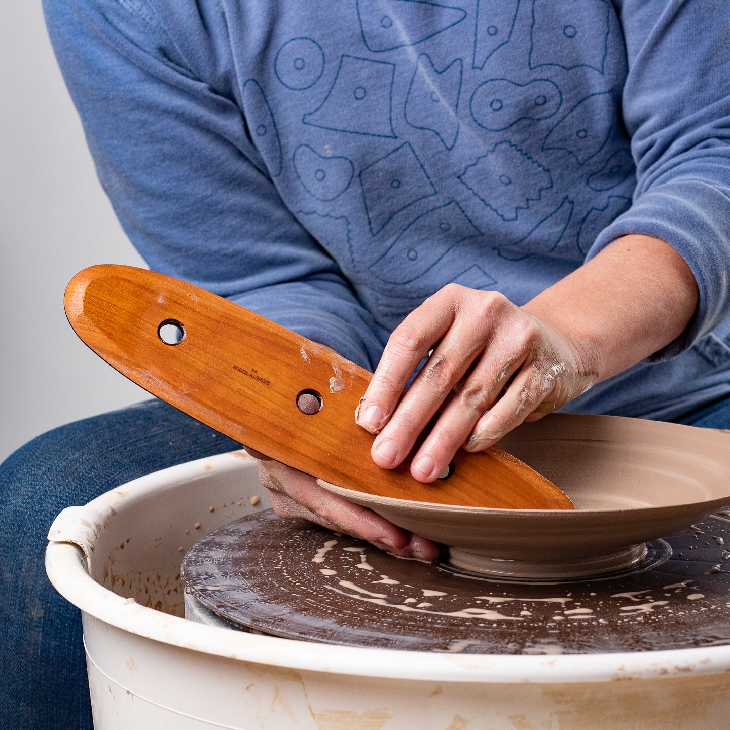 ceramicist uses Garrity Tools F4 wooden pottery tool on clay bowl