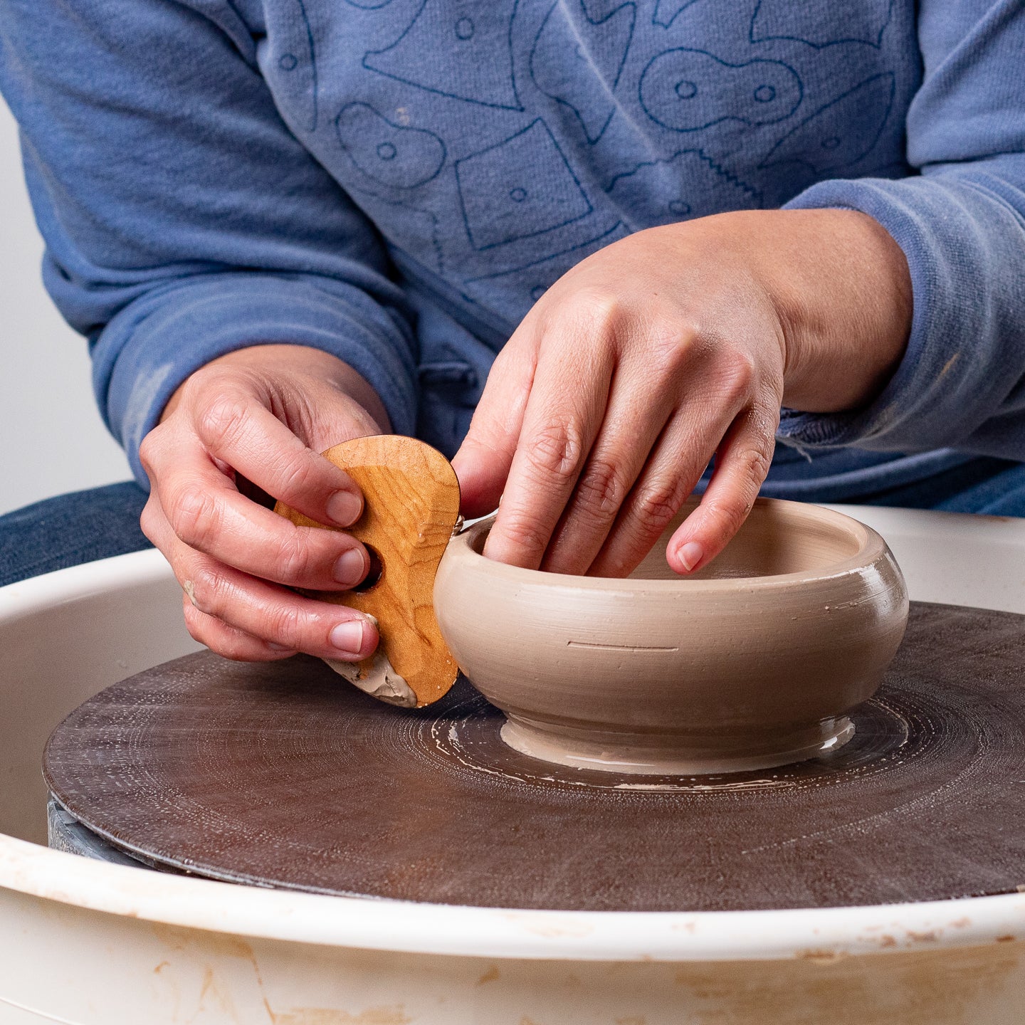 ceramicist uses Garrity Tools K1 wooden pottery tool on clay bowl