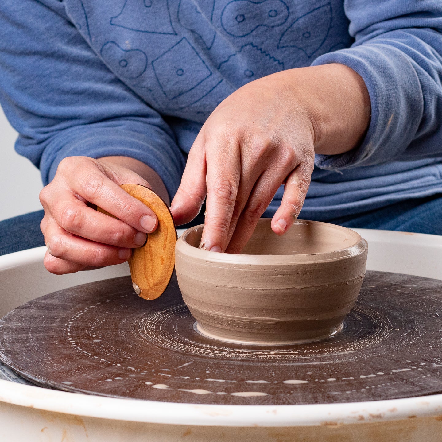 ceramicist uses Garrity Tools K1 wooden pottery tool on clay bowl