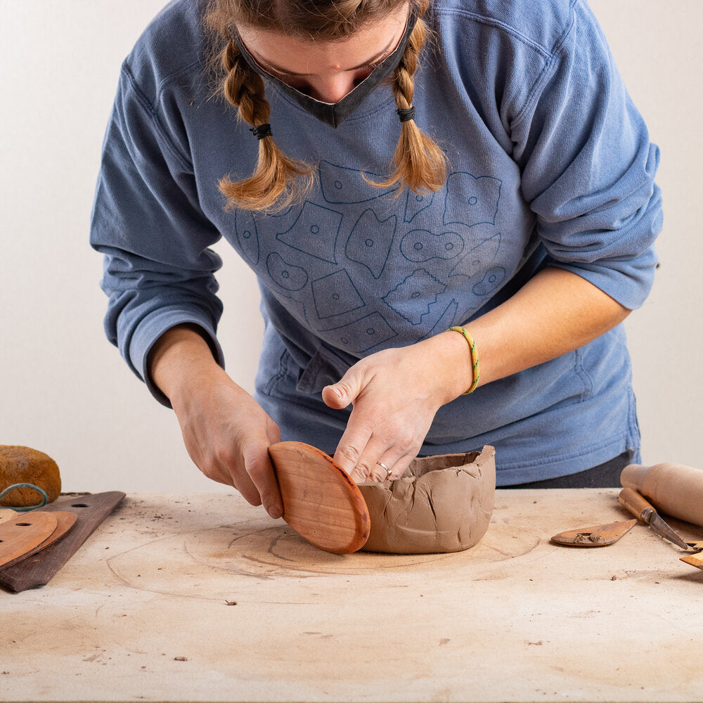 ceramicist uses Garrity Tools wooden paddle to shape clay