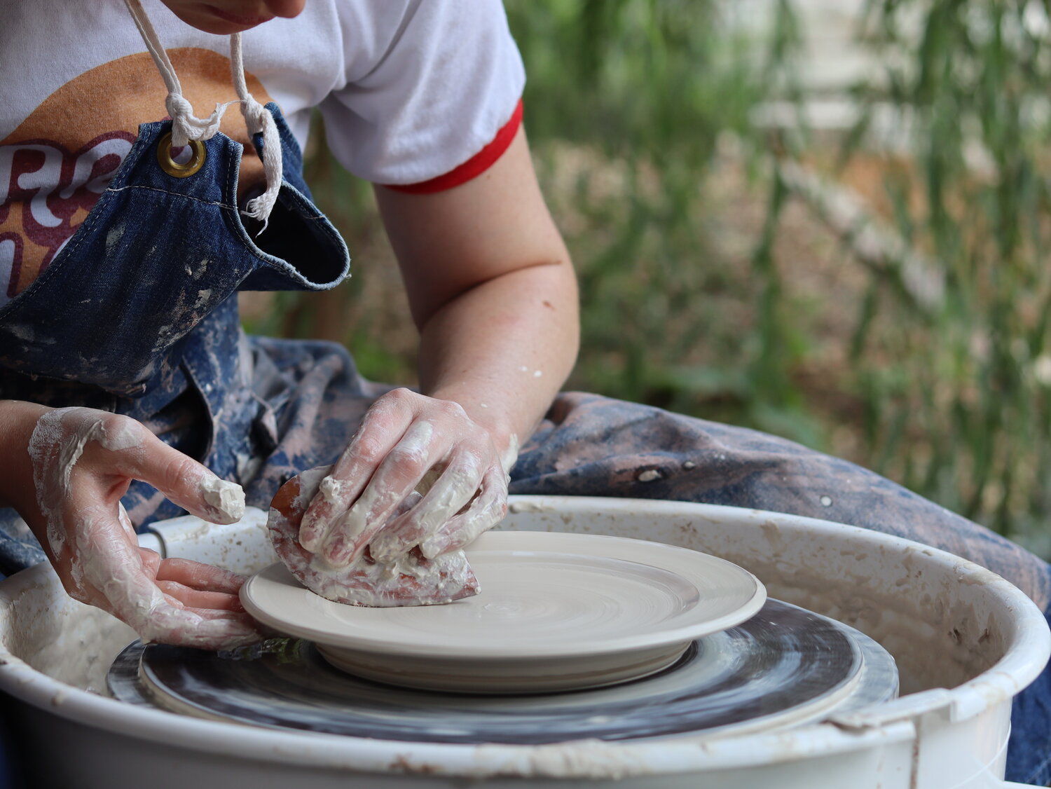 ceramicist uses Garrity Tools S2 pottery rib on clay plate