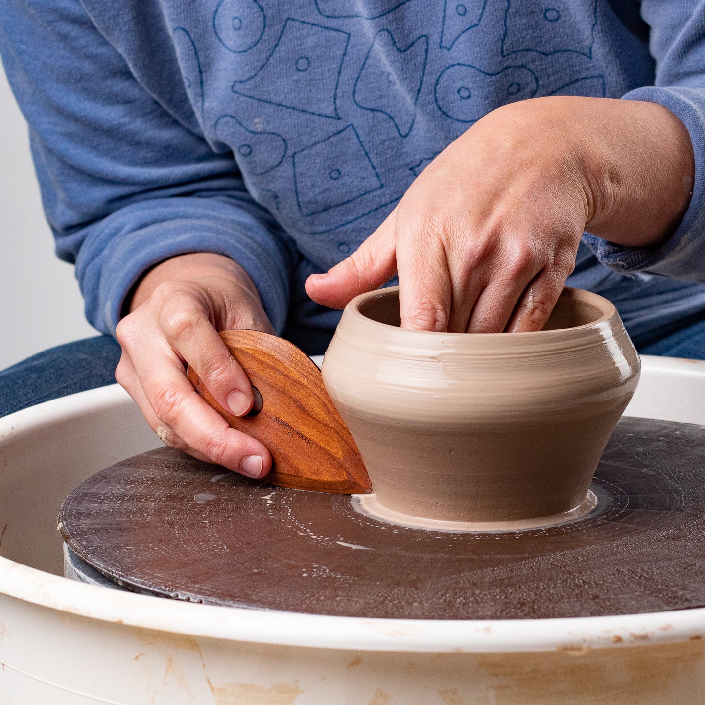 ceramicist uses Garrity Tools R1 wooden pottery tool on clay bowl