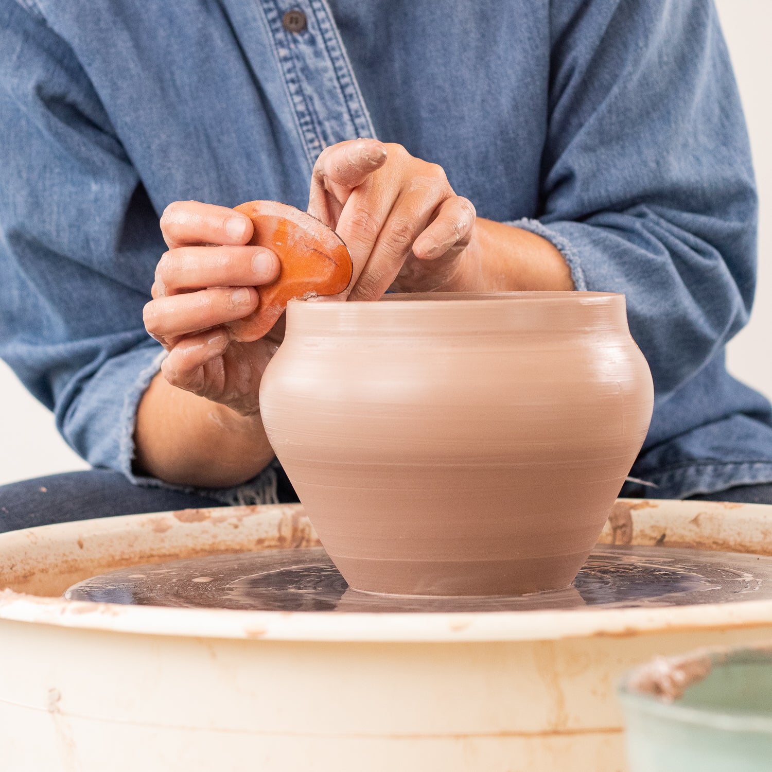 ceramicist uses Garrity Tools K1 wooden pottery tool on clay pot