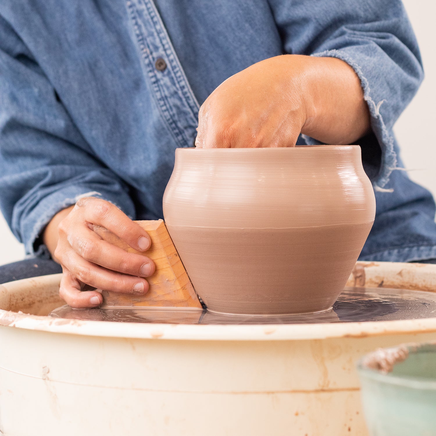 ceramicist uses Garrity Tools N3 wooden pottery tool on clay pot