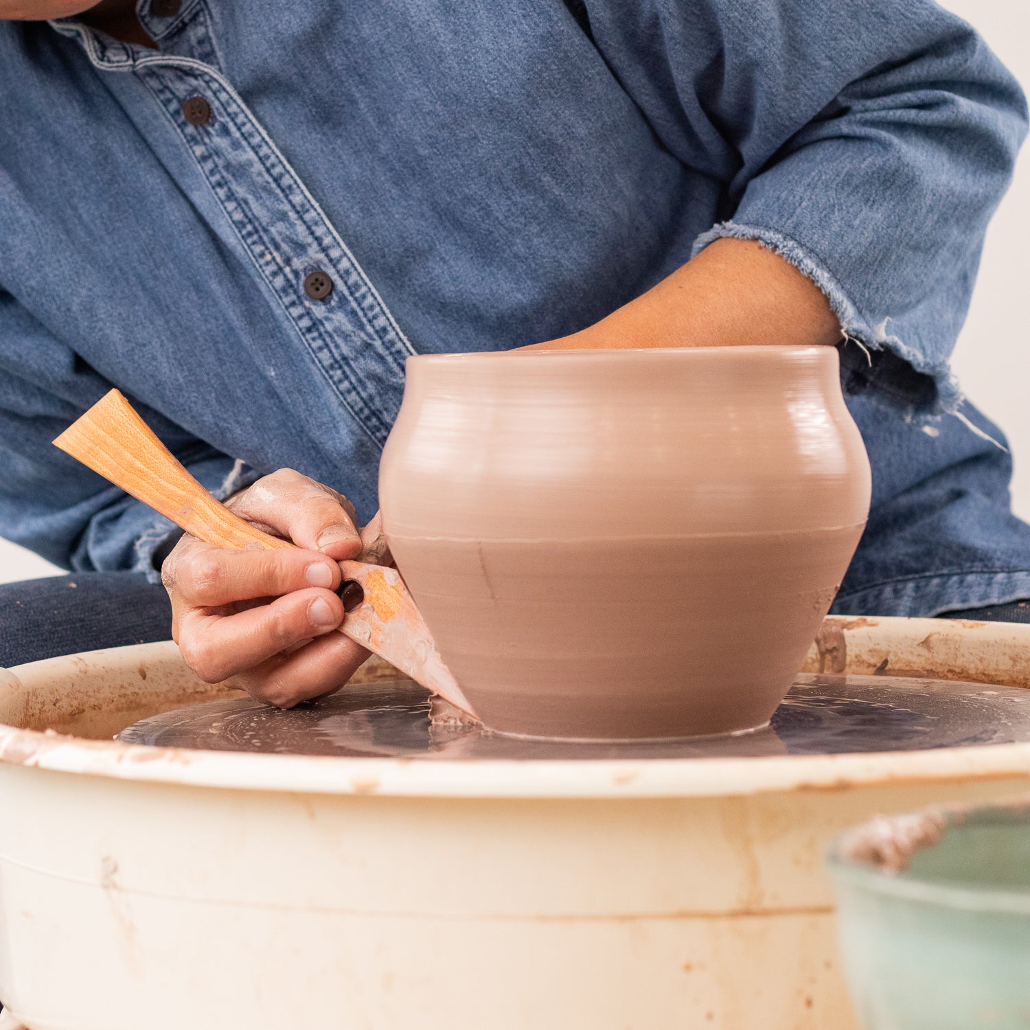 ceramicist uses Garrity Tools T1 wooden pottery tool on clay pot