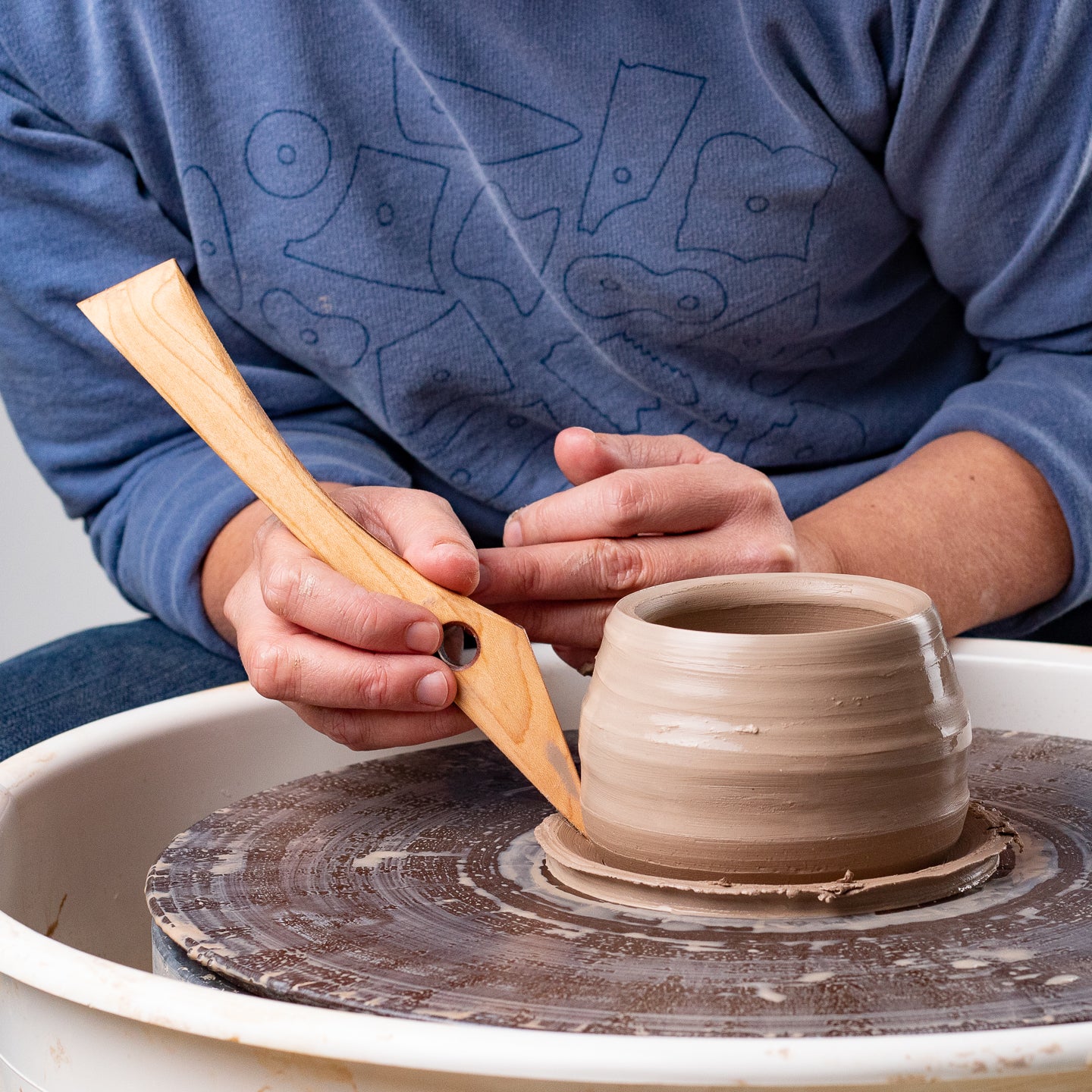 ceramicist uses Garrity Tools T1 wooden pottery tool on clay pot