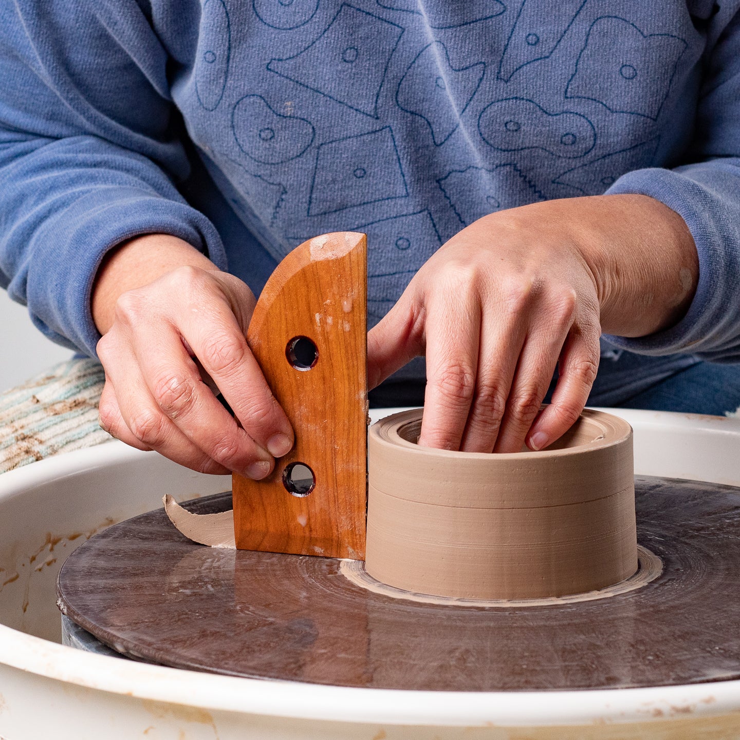 ceramicist uses Garrity Tools T5 wooden pottery tool on clay cylinder