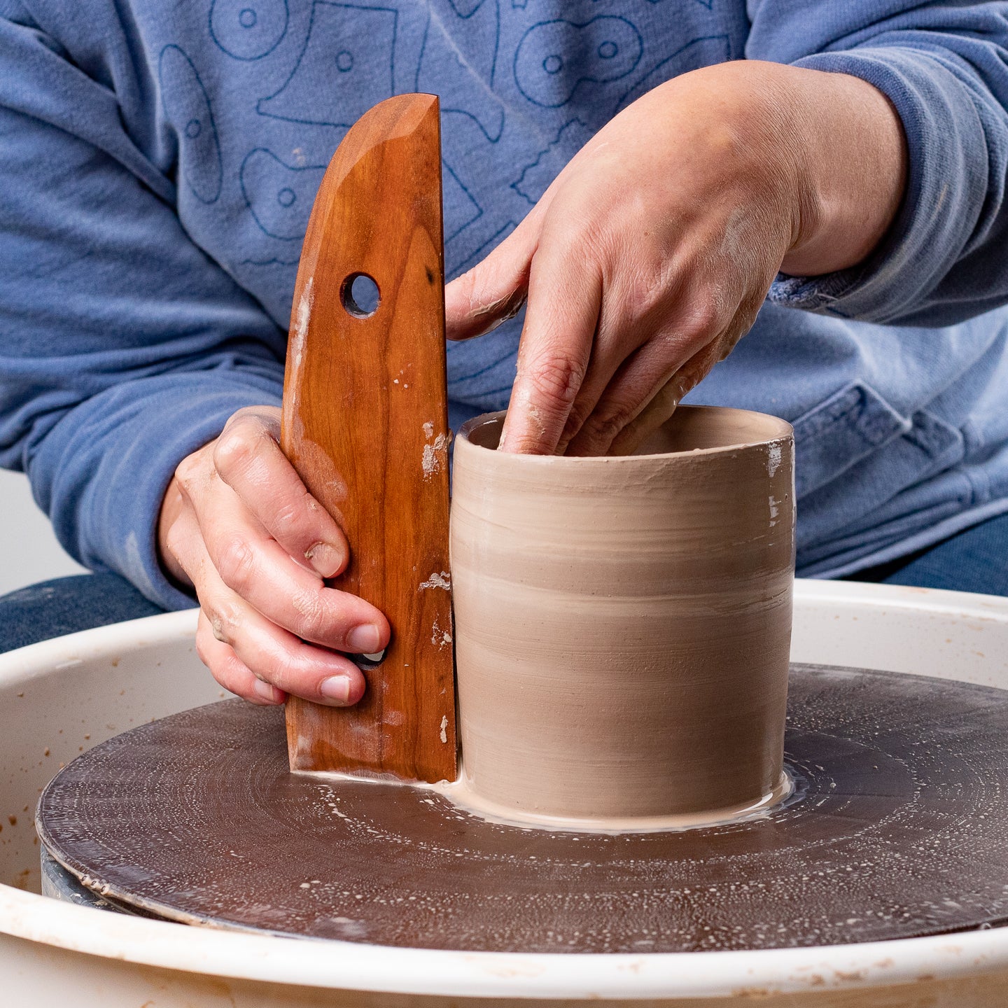 ceramicist uses Garrity Tools T6 wooden pottery tool on clay cylinder