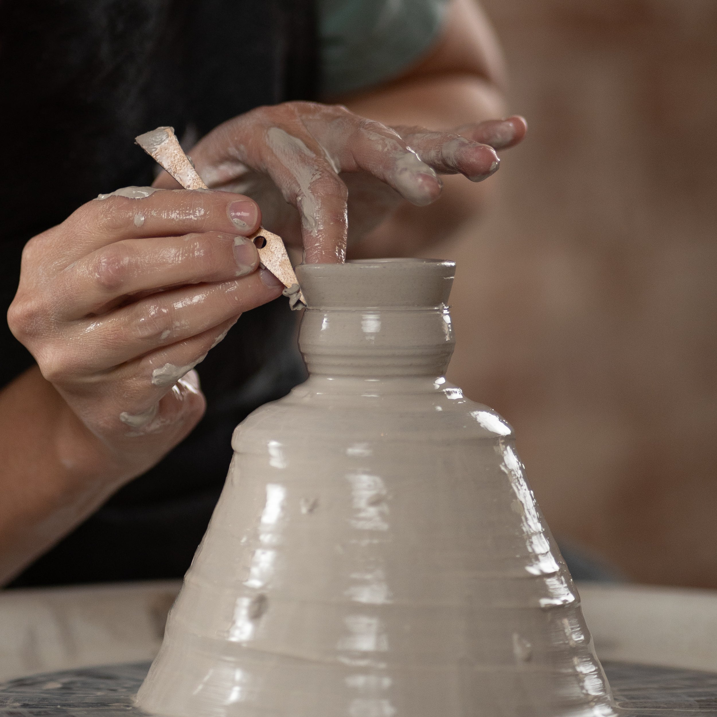 ceramicist uses tiny T1 pottery tool to throw off the clay hump