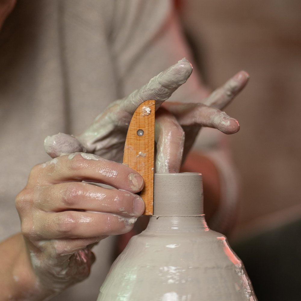 ceramicist uses tiny T6 pottery tool to throw off the clay hump