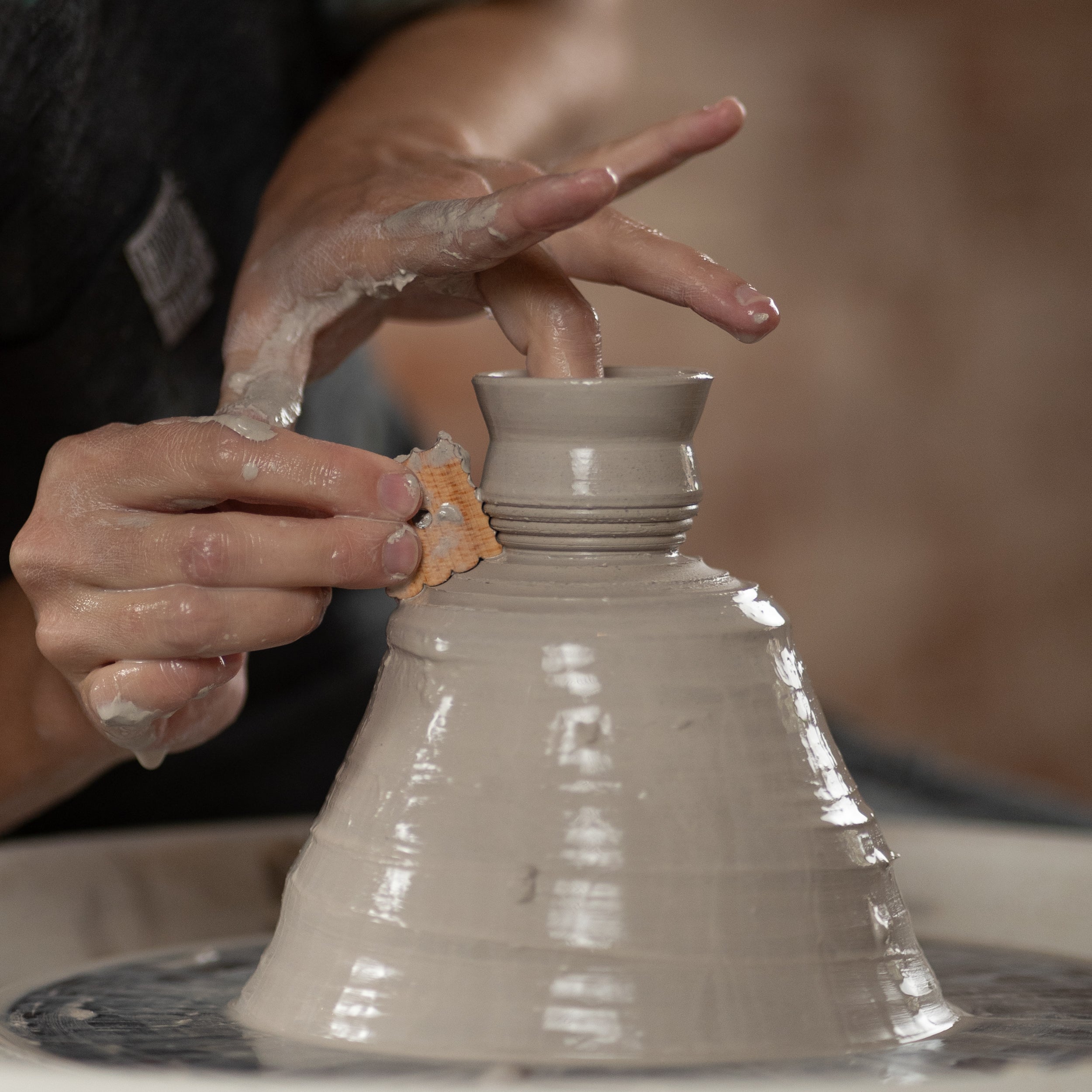 ceramicist uses tiny Texture 1 pottery tool to throw off the clay hump