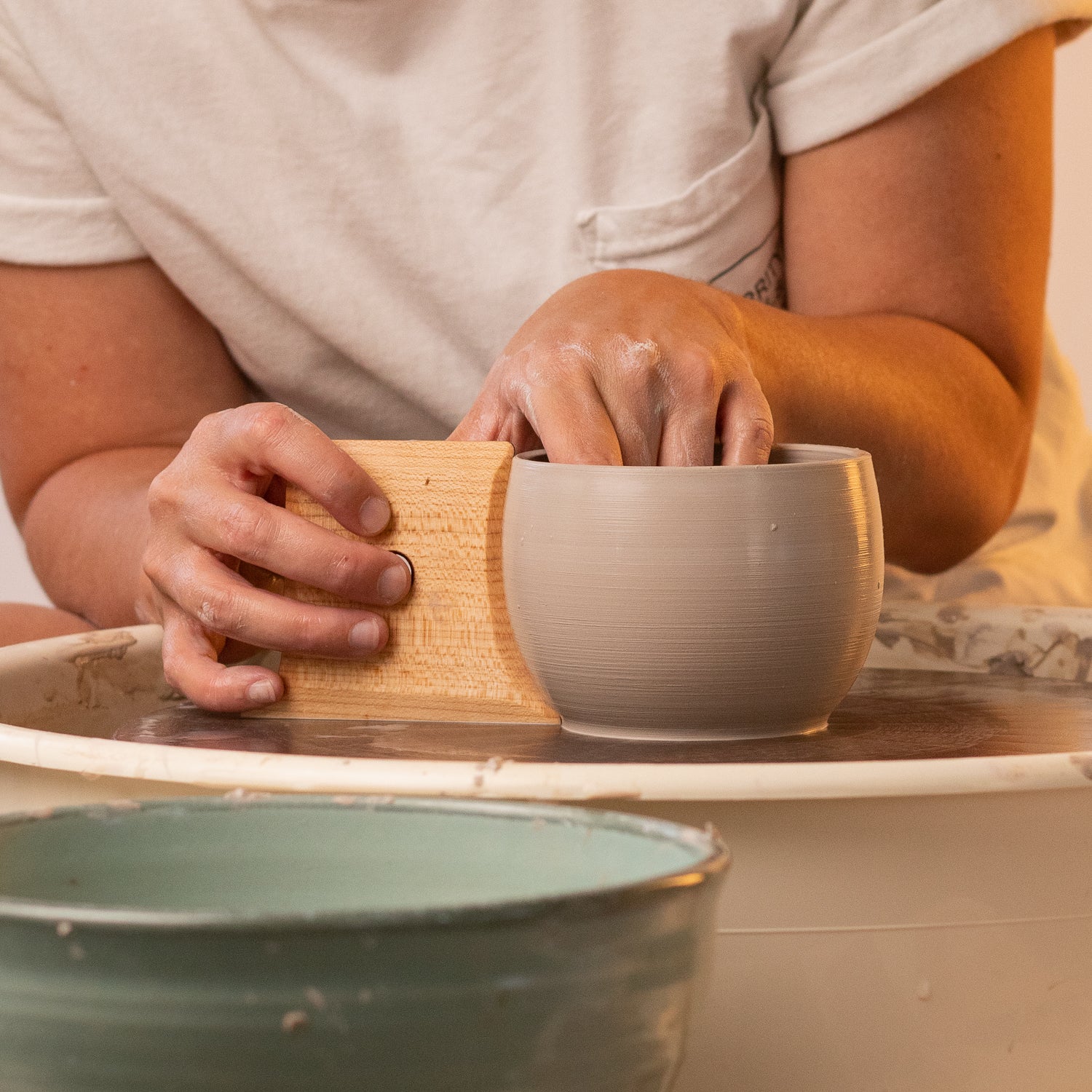 ceramicist uses Garrity Tools Unfoot 3 wooden pottery tool on clay mug