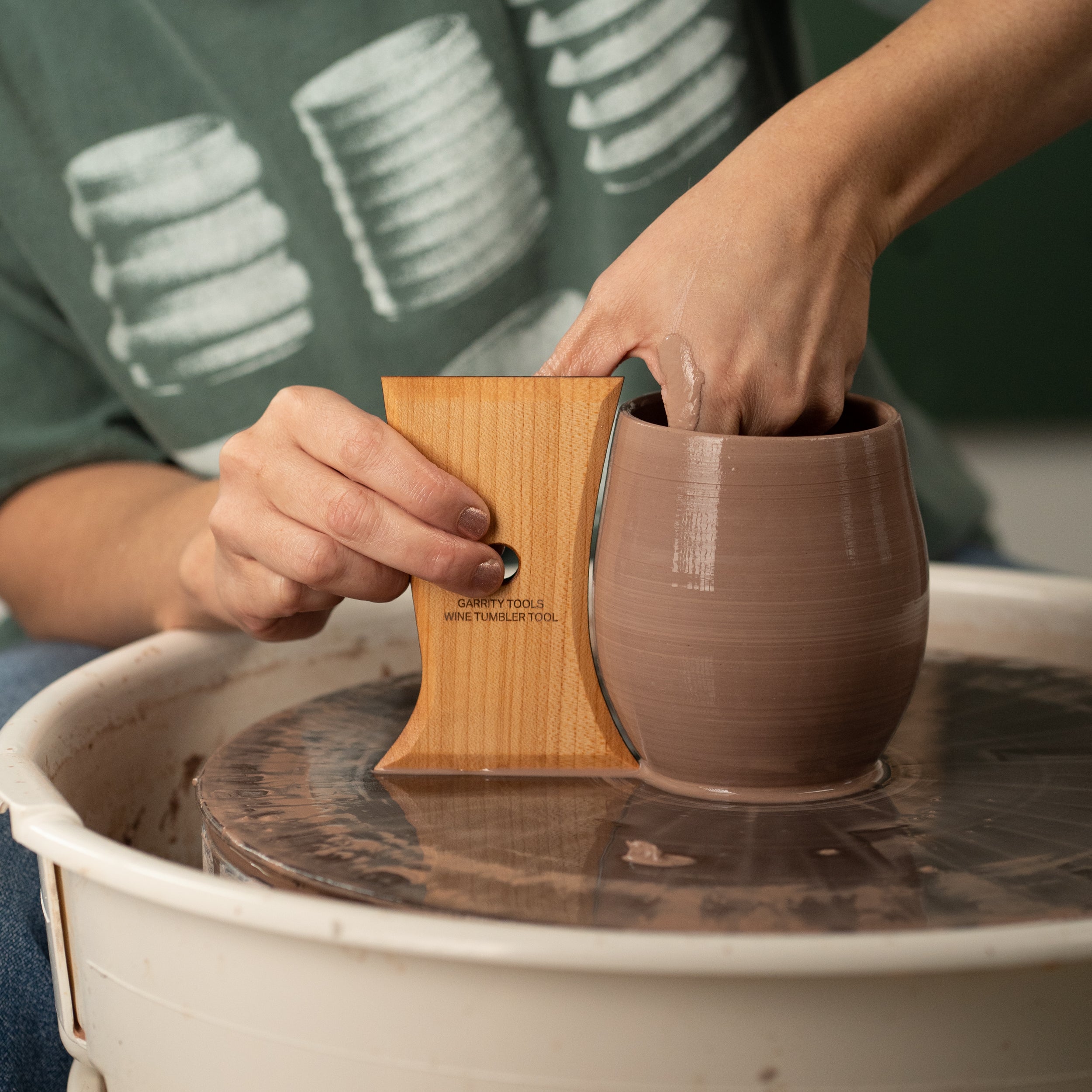 ceramicist uses Garrity Tools Wine Tumbler wooden pottery tool to make a clay wine glass