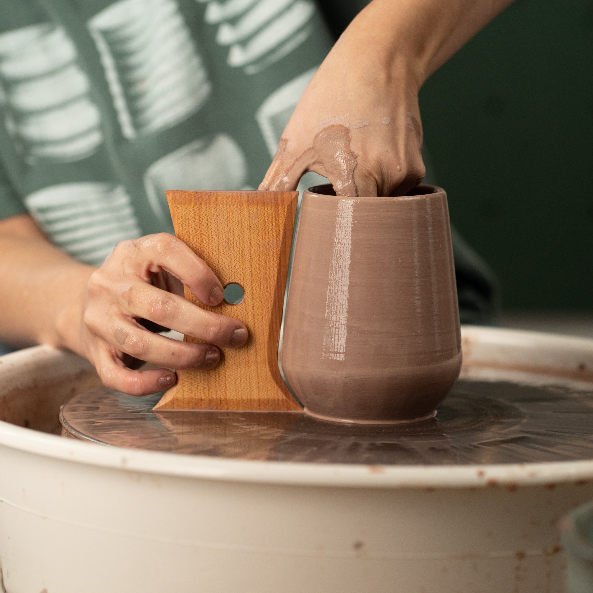 ceramicist uses Garrity Tools Wine Tumbler wooden pottery tool to make a clay wine glass